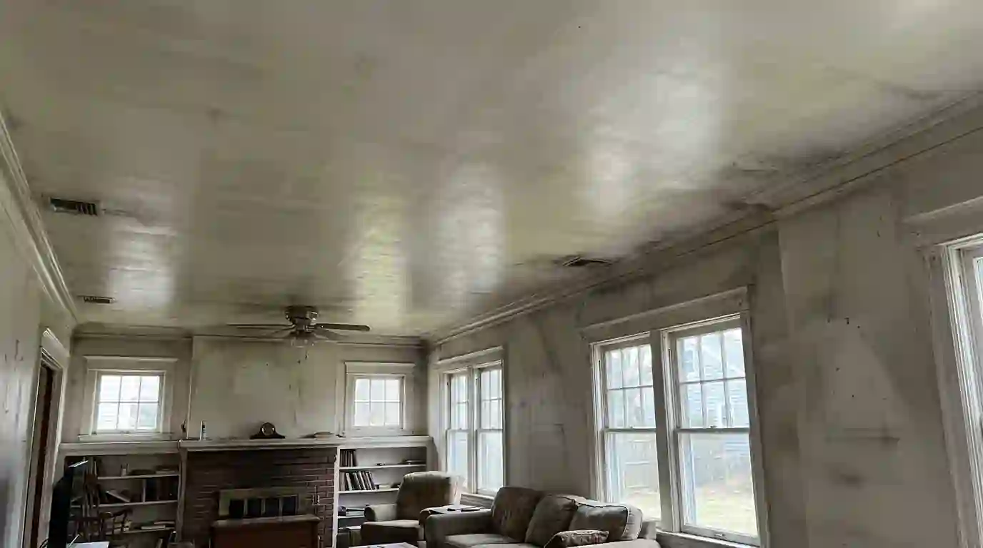 Oily soot film on a living room wall with a clean test square